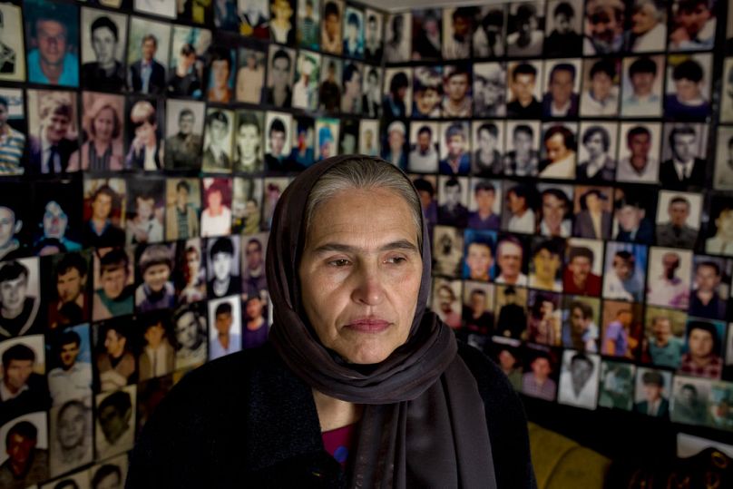 A Bosniak woman infront of photographs of victims