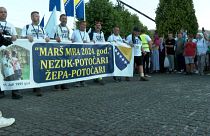 Menschen halten einen Banner bei dem Friedensmarsch in Srebrenica.