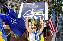 Ukraynalı mülteci Mariia Hlyten, Washington'daki NATO zirvesinin önünde bir tabela tutuyor.