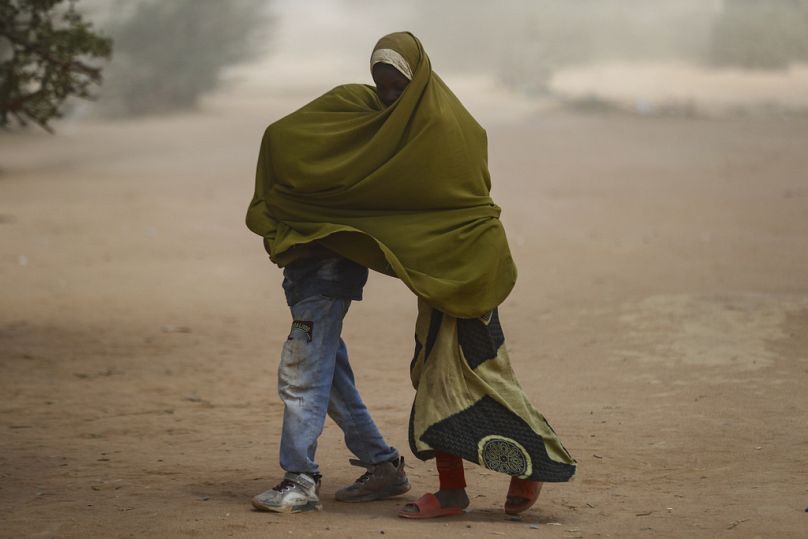 Somali refugee children cover themselves as a dust storm blows through the Dadaab refugee camp in northern Kenya 