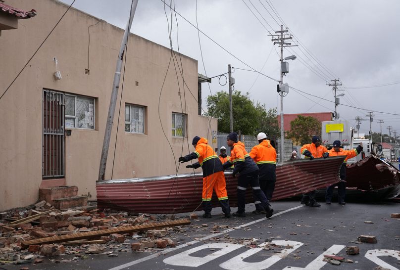 Rescue workers among damaged buildings in the Wynberg neighborhood of Cape Town, South Africa, Thursday, July 11, 2024.