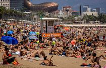 Des personnes prennent un bain de soleil sur la plage de Barcelone, en Espagne, le 9 juillet 2021. 