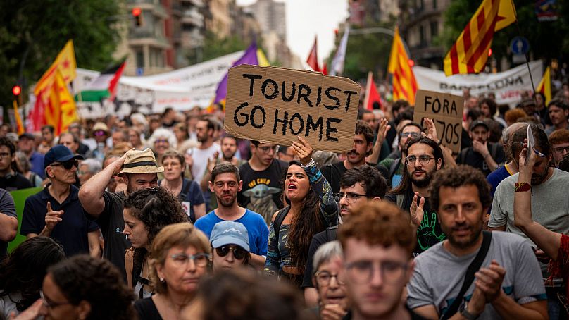 Environ 500 habitants de Barcelone protestent contre le tourisme de masse lors d'une exposition de voitures de course de Formule 1 dans la ville espagnole, le 19 juin 2024. 