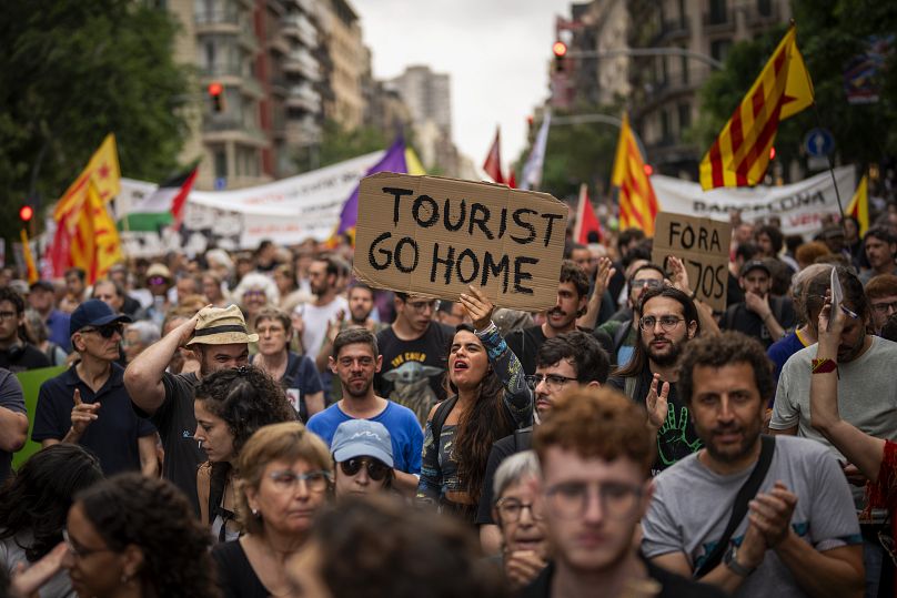 Manifestantes marcham gritando slogans contra a Formula 1 Barcelona Fan Festival no centro de Barcelona, 19 de junho de 2024