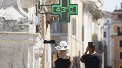 Un uomo fotografa la temperatura di 43 gradi C (109 gradi F) registrata al sole fuori da una farmacia nel centro di Roma, giovedì 11 luglio 2024.