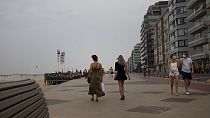 Pessoas caminham no passeio marítimo ao longo da costa na estância balnear belga de Knokke, na Bélgica, terça-feira, 11 de agosto de 2020. 