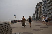 Pessoas caminham no passeio marítimo ao longo da costa na estância balnear belga de Knokke, na Bélgica, terça-feira, 11 de agosto de 2020. 