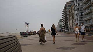 La gente camina por el paseo marítimo a lo largo de la costa en la localidad costera belga de Knokke, Bélgica, martes 11 de agosto de 2020. 