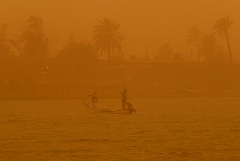 Fishermen navigate on the Shatt al-Arab waterway during a sandstorm in Basra, Iraq