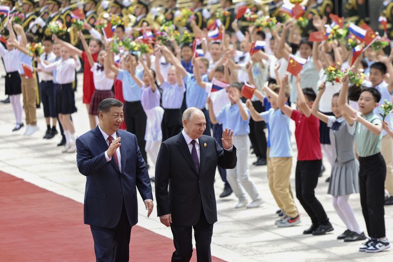 Chinese President Xi Jinping and Russian President Vladimir Putin wave gesture during a welcome ceremony at the Great Hall of the People in Beijing, 16 May 2024