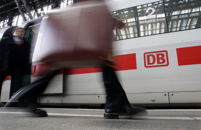 A passenger walks by in front of an ICE express train in Cologne, April 2008