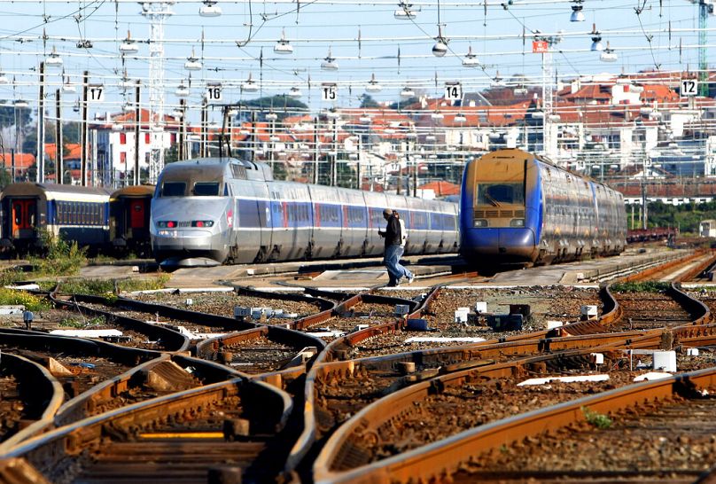 Railway workers cross railways at the train station in Hendaye, southwestern France, November 2008