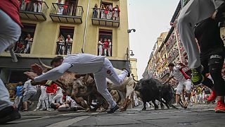 Des fêtards courent avec des taureaux du ranch de Jandilla lors du sixième jour de la course de taureaux des fêtes de San Fermín à Pampelune, le vendredi 12 juillet 2024
