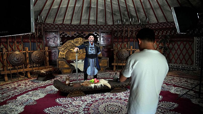 A tourist wears an ottoman custom for a photograph, during his visit to Bozdag's outdoor film studio in Istanbul, Turkey, 12 June 2024. 