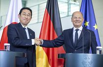 Japanese Prime Minister Fumio Kishida and German Chancellor Olaf Scholz shake hands during their meeting at the Federal Chancellery in Berlin, July 12, 2024