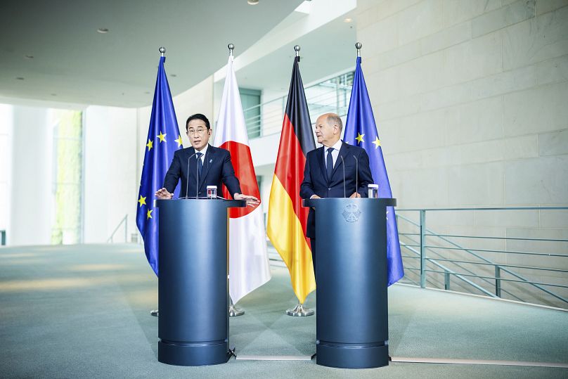 O primeiro-ministro japonês, Fumio Kishida, e o chanceler alemão, Olaf Scholz, apertam as mãos durante o seu encontro na Chancelaria Federal em Berlim, a 12 de julho de 2024