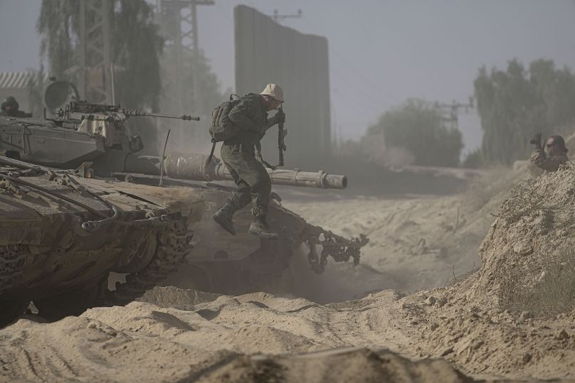 Un soldado israelí se apea de su tanque cerca de la frontera entre Israel y Gaza, 12 de julio de 2024.