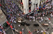 Feiernde rennen mit Stieren von der José Escolar-Ranch am siebten Tag der Stierrennen bei den Sanfermínes in Pamplona, 13. Juli 2024. 