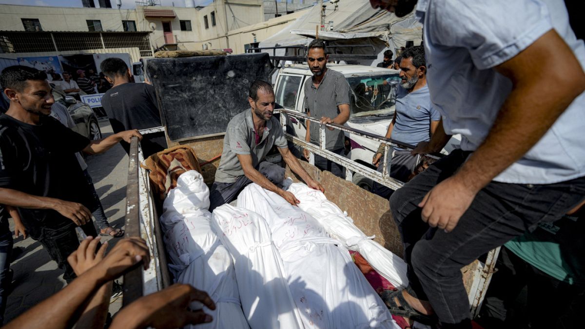 Palestinians gather near the bodies of their relatives killed in the Israeli bombardment of the Gaza Strip, at a hospital morgue in Deir al-Balah, Saturday, July 13, 2024.