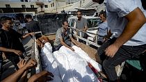 Palestinians gather near the bodies of their relatives killed in the Israeli bombardment of the Gaza Strip, at a hospital morgue in Deir al-Balah, Saturday, July 13, 2024. (AP