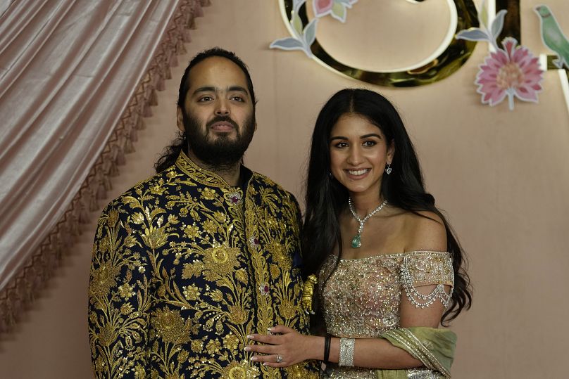 Anant Ambani, left, and Radhika Merchant pose for photographers during their pre-wedding ceremony in Mumbai, July 5, 2024