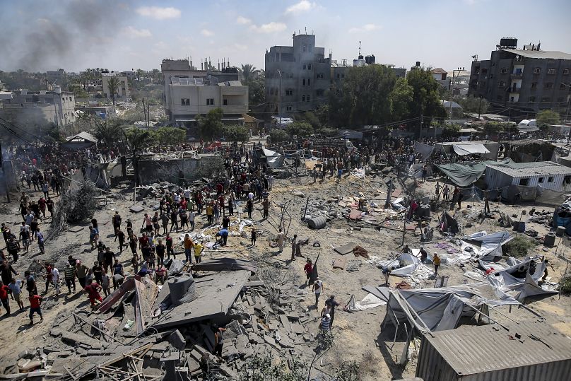 Palestinians inspect the damage at a site hit by an Israeli bombardment on Khan Younis, July 13, 2024