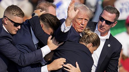 Republican presidential candidate former President Donald Trump is helped off the stage by U.S. Secret Service agents at a campaign event in Butler, Pa., on Saturday, July 13,