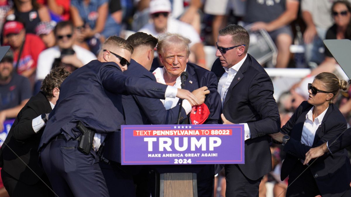 El candidato presidencial republicano, el expresidente Donald Trump, es ayudado a bajar del escenario en un acto de campaña en Butler, Pensilvania, el sábado,