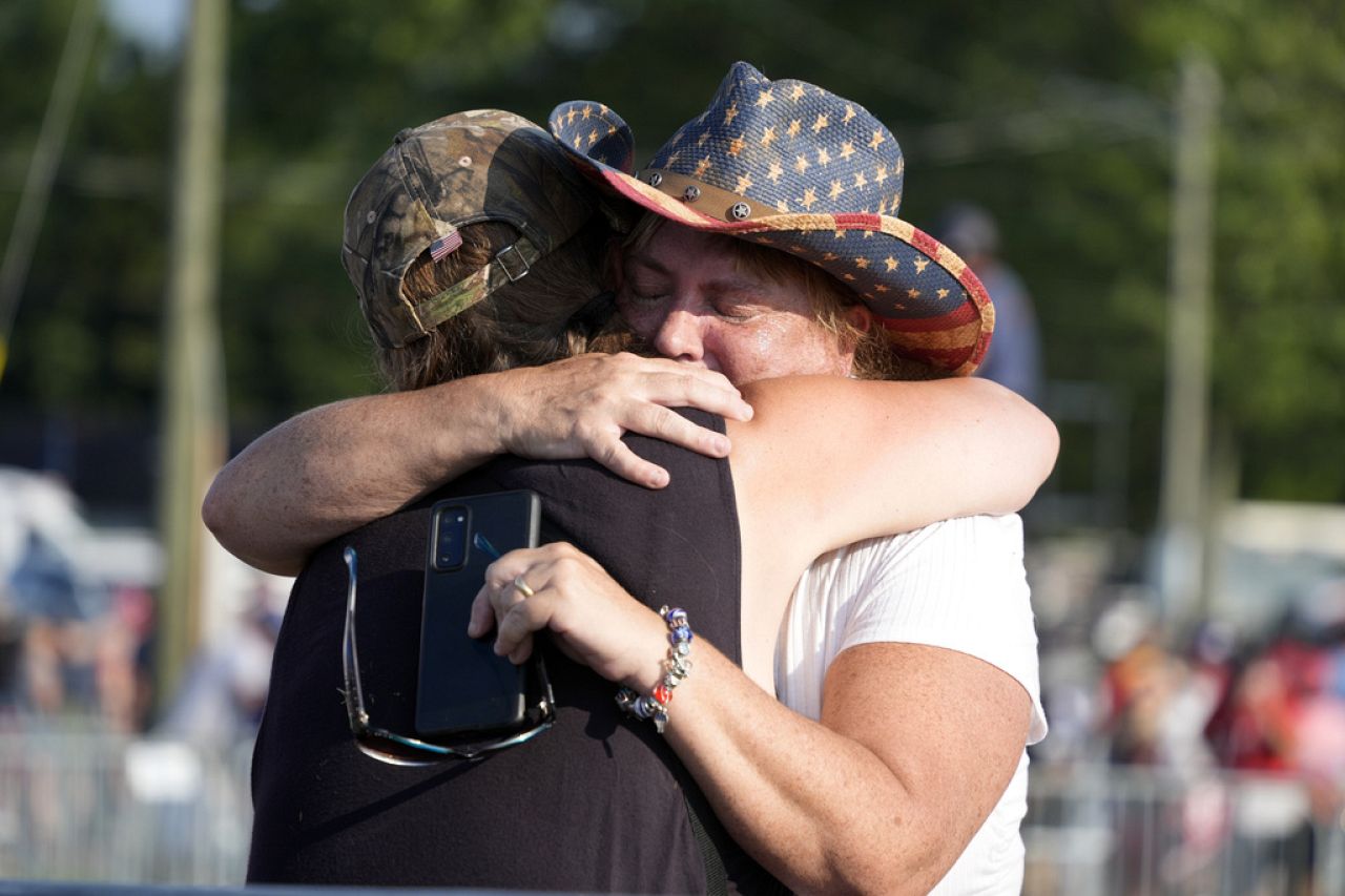 People hug after Republican presidential candidate former President Donald Trump was helped off the stage