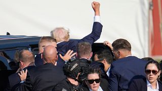 Republican presidential candidate former President Donald Trump is helped off the stage at a campaign event in Butler