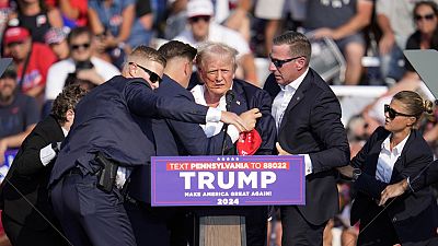 El candidato presidencial republicano, el expresidente Donald Trump, es ayudado a bajar del escenario en un acto de campaña en Butler, Pensilvania, el sábado,