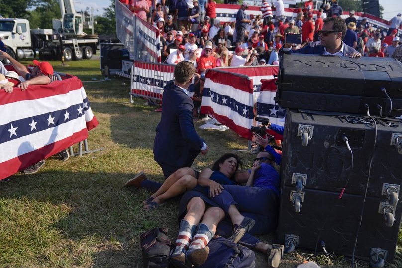 People react during a campaign rally with Republican presidential candidate former President Donald Trump