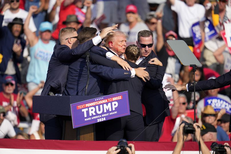 Republican presidential candidate former President Donald Trump is helped off the stage