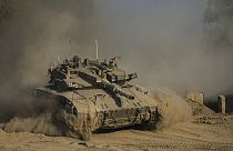 An Israeli soldier moves on the top of a tank near the Israeli-Gaza border, as seen from southern Israel, Sunday, July 14, 2024. 