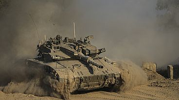 An Israeli soldier moves on the top of a tank near the Israeli-Gaza border, as seen from southern Israel, Sunday, July 14, 2024. 