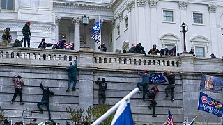 هواداران دونالد ترامپ در واشنگتن از دیوار غربی ساختمان کنگره بالا می روند؛ روز چهارشنبه، ۶ ژانویه ۲۰۲۱