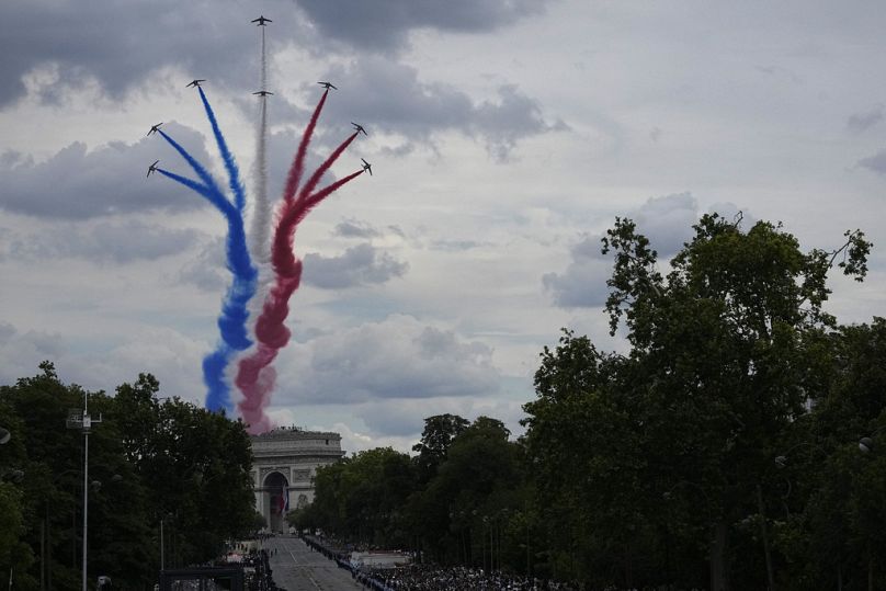 Os jactos da Patrouille de France sobrevoam o Arco do Triunfo durante o desfile do Dia da Bastilha, domingo, 14 de julho de 2024, em Paris.