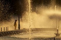 Un employé municipal se rafraîchit près d'une fontaine à Bucarest, en Roumanie, le jeudi 11 juillet 2024, alors que les températures ont dépassé 39 °C.