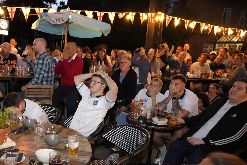 Des supporters anglais réagissent en regardant l'Espagne remporter la finale de l'Euro 2024, dans un pub du village de Wimbledon, à Londres, le dimanche 14 juillet 2024.