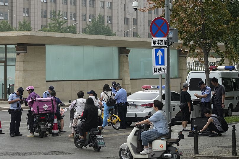 Policemen check people's identification on a street in Beijing where the Communist Party's 205-member Central Committee is holding its third plenum 