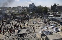 فلسطينيون يتفقدون الأضرار التي لحقت بموقع تعرض للقصف الإسرائيلي على خان يونس جنوب قطاع غزة، السبت، 13 يوليو 2024.