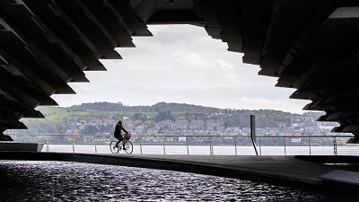 A cyclist rides along the River Tay in Dundee, Scotland.