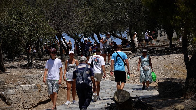 Touristen schwitzen in der Hitze, während die Temperaturen nahe der Akropolis steigen