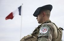 Um soldado junto à bandeira francesa no acampamento militar montado no bosque de Vincennes, segunda-feira, 15 de julho de 2024, nos arredores de Paris.