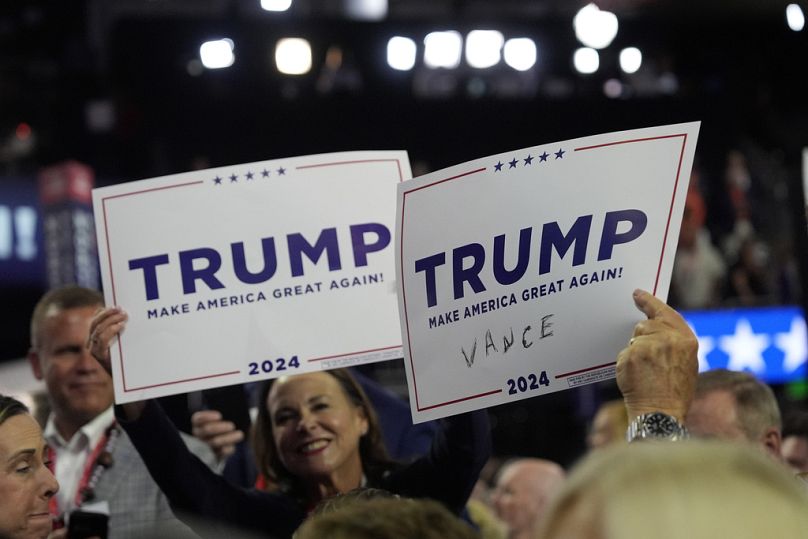 Delegates hold a sign with a hastily scrawled 'Vance" written in as Vance arrives on the floor during the first day of the 2024 Republican National Convention