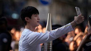 Jin, the oldest member of K-pop supergroup BTS, males a selfie with the Olympic torch, Sunday, July 14, 2024 in Paris.