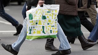 Un hombre con una bolsa de la compra cruza una calle de Berlín (Alemania)