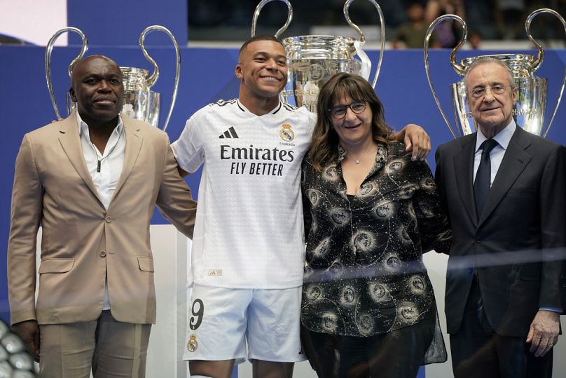 Kylian Mbappe, of France, poses with his parents and Real Madrid President Florentino Perez, right, after being presented to fans as a new Real Madrid player.