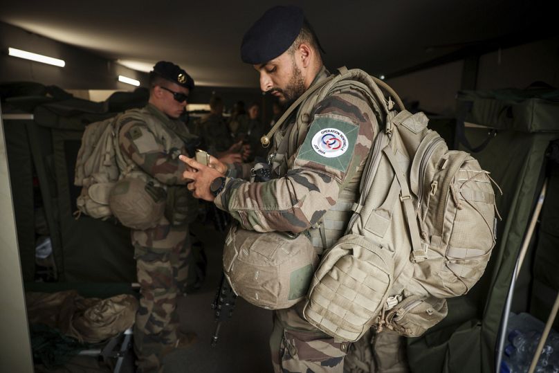 Soldados preparam-se para uma patrulha no acampamento militar instalado no bosque de Vincennes, segunda-feira, 15 de julho de 2024, nos arredores de Paris.