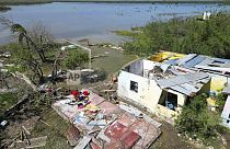 سيدة تبحث عمّا تبقى من ممتلكاتها في منزلها الذي ضربه إعصار بيريل في بورتلاند كوتاج بجامايكا هذا الشهر 